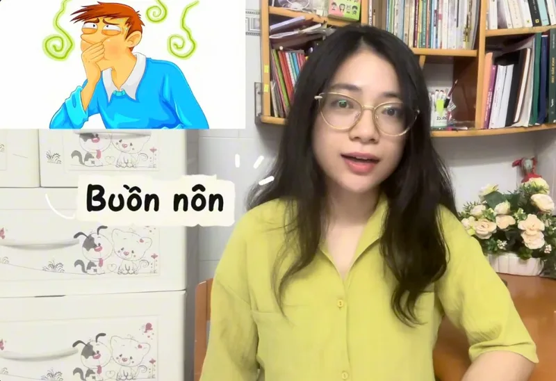 Cartoon of a man looking nauseous next to the words buồn nôn