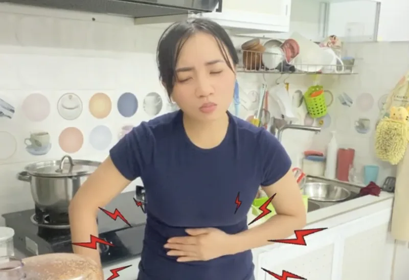 Ngọc holding her stomach