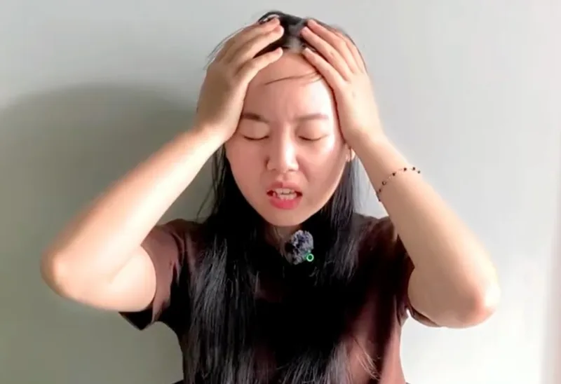 Tâm holding her head