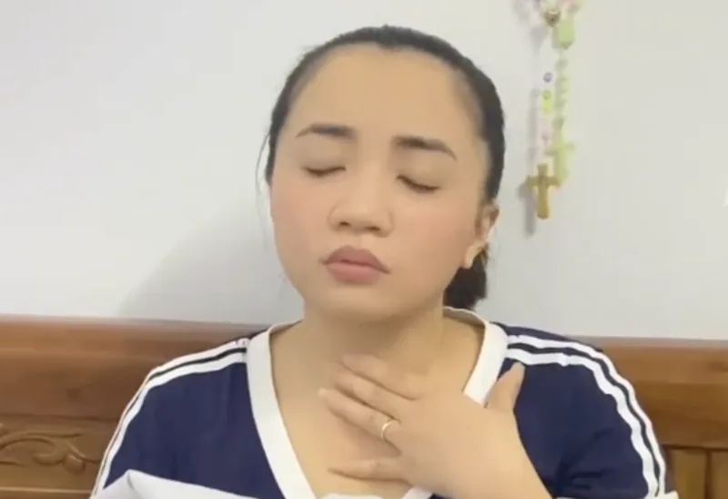 A woman with her hand on her throat