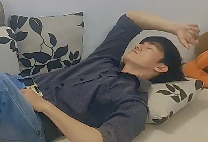A man lying down with his eyes closed
