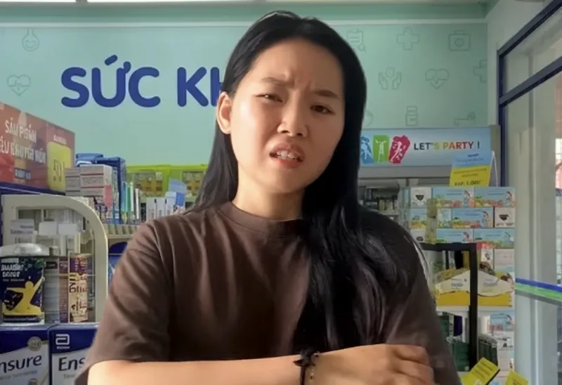 Tâm scratching her arm in a pharmacy