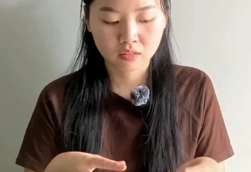 Tâm looking at her hands, one of them blurred